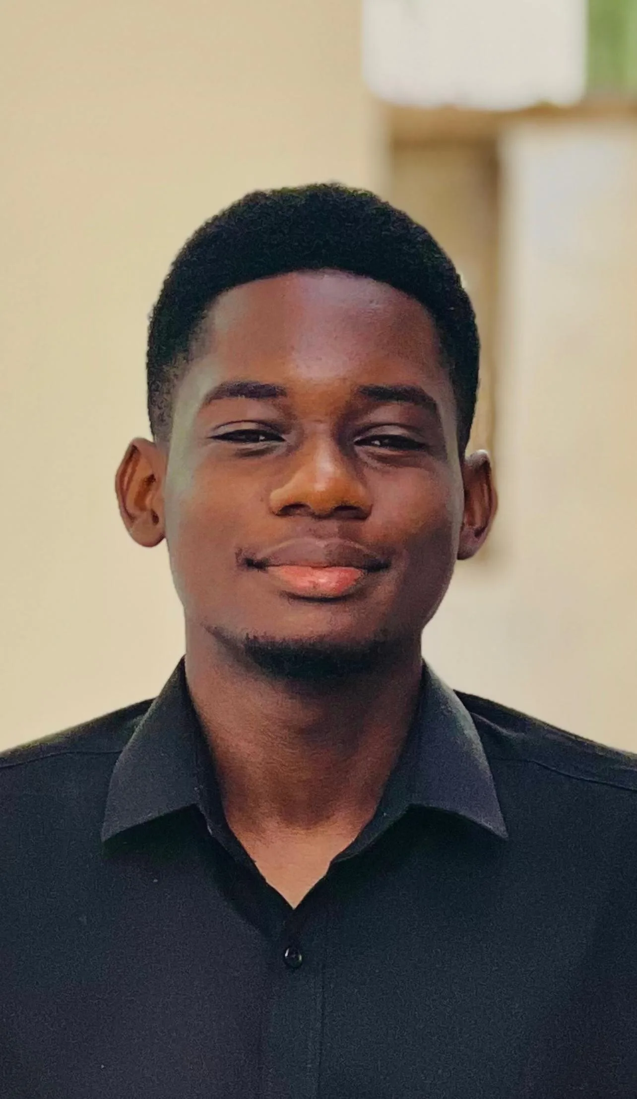 Portrait of Harry Mbwasi wearing a black shirt.